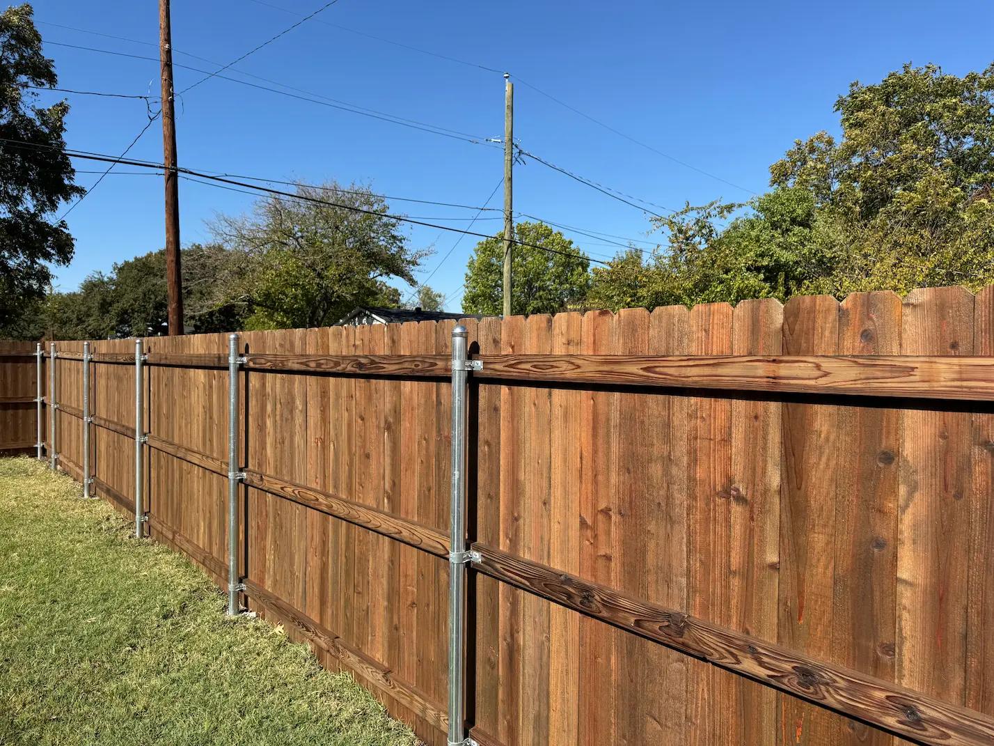 Black removable mesh pool safety fence installed around a backyard pool and spa in Dallas, TX